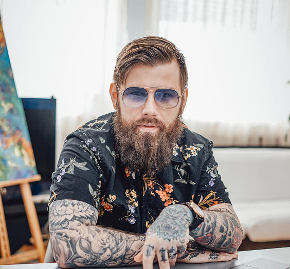 About Us 19 tattooed guy sits at table with papers and laptop 2025 01 25 22 02 23 utc 1